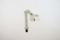Handmade cream botanical pacifier clip with green snap button and silver metal clip on white studio background
