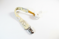 Handmade golden yellow floral pacifier clip with silver metal clasp on white studio background