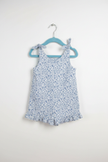 Handmade blue ditsy floral toddler romper with tie straps and ruffle hem on white studio background