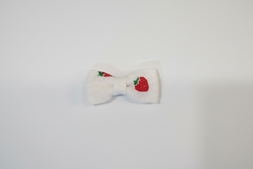 Handmade strawberry print baby hair bow on white studio background