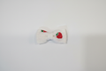 Handmade strawberry print baby hair bow on white studio background