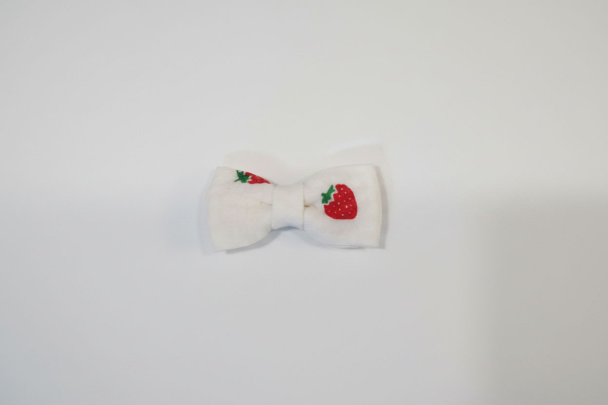 Handmade strawberry print baby hair bow on white studio background