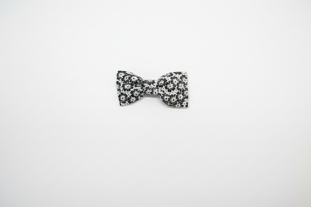 Handmade black and white floral daisy baby hair bow on white studio background