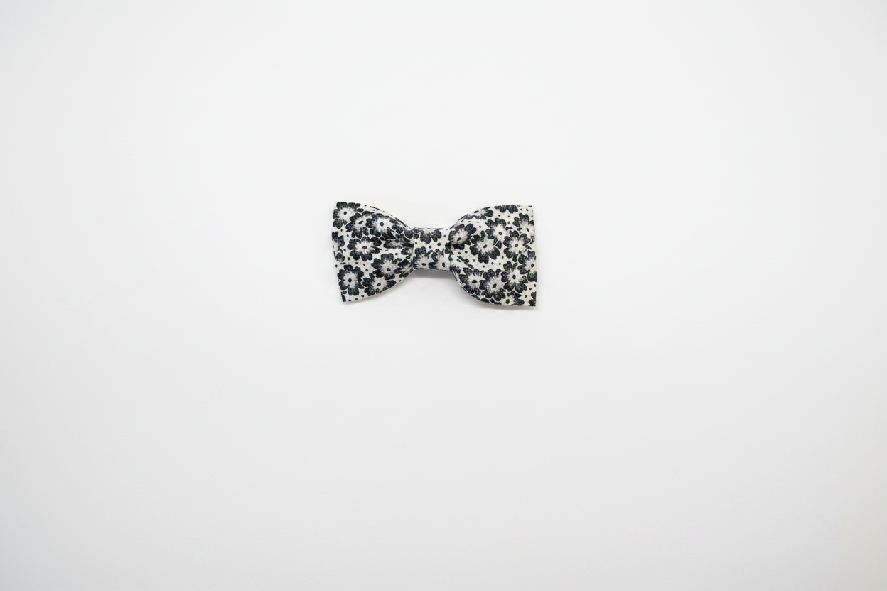 Handmade black and white floral daisy baby hair bow on white studio background
