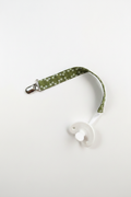 Handmade olive green daisy pacifier clip with silver metal clip and white pacifier on white studio background