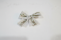 Close-up of single handmade sage vine lace baby hair bow on white studio background