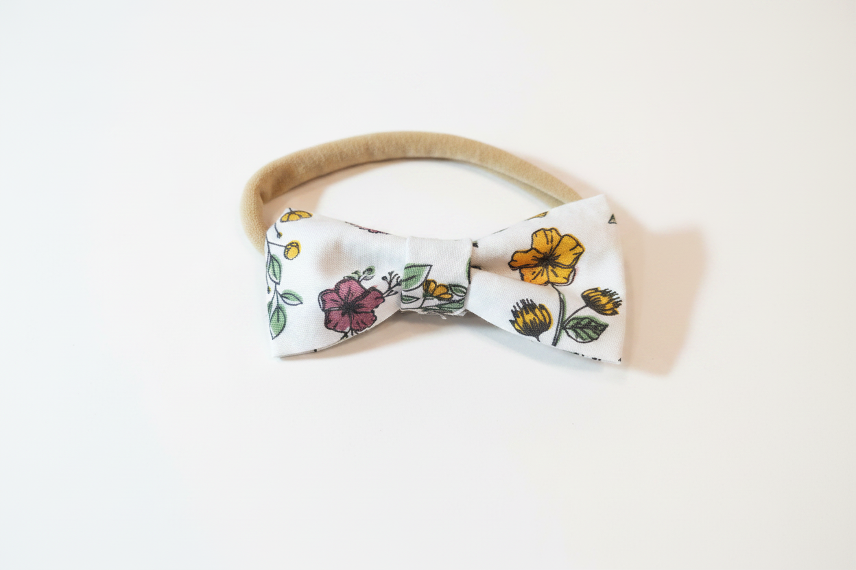Handmade wildflower print bow baby nylon headband on white studio background